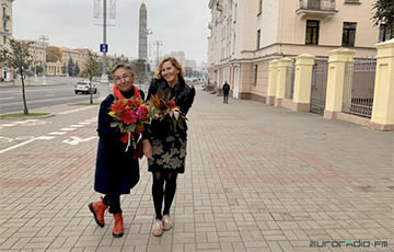 Люди с цветами гуляют по Площади Победы в Минске
