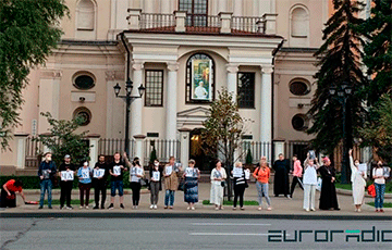 Возле Кафедрального собора в Минске люди стоят с портретами митрополита Тадеуша Кондрусевича