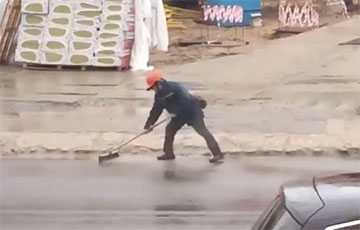 Видеофакт: Минский строитель под дождем разгоняет лужи метлами