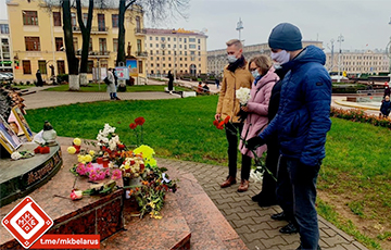 Люди несут цветы и свечи к Красному костелу в Минске