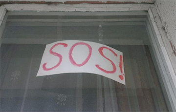 Фотофакт: Плакаты SOS! в окнах минской квартиры